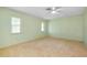 Bright bedroom with neutral carpet, two windows and a ceiling fan offers a spacious and inviting atmosphere at 49 Sandstone Cir, Venice, FL 34293