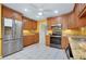 Well-lit kitchen with stainless steel appliances, light wood cabinets, and tile floors at 49 Sandstone Cir, Venice, FL 34293