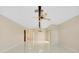 Bright living room with decorative ceiling beams, ceiling fan, and pristine tile flooring at 49 Sandstone Cir, Venice, FL 34293