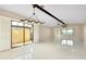 Spacious living room with white tile flooring, a decorative light, and sliding door access to patio at 49 Sandstone Cir, Venice, FL 34293