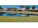 Scenic view of waterfront homes reflecting in a serene community pond and lush landscaping at 49 Sandstone Cir, Venice, FL 34293