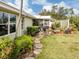 Landscaped backyard featuring a stone pathway leading to the screened-in lanai at 503 Clubside Cir # 47, Venice, FL 34293