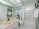 Clean bathroom with a white vanity, a shower-tub combo, and green accent walls at 503 Clubside Cir # 47, Venice, FL 34293