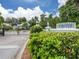 Gated community entrance with lush landscaping and clear signage under a bright, sunny sky at 503 Clubside Cir # 47, Venice, FL 34293