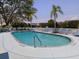 Tranquil community pool with clear blue water, palm trees, and seating for residents to enjoy at 503 Clubside Cir # 47, Venice, FL 34293