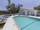 Community pool with crystal clear water, blue lounge chairs and tables under a bright sunny sky at 503 Clubside Cir # 47, Venice, FL 34293