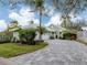 Charming one-story home featuring a brick paved driveway, lush landscaping, and an attached two-car garage at 503 Clubside Cir # 47, Venice, FL 34293