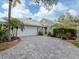 Charming single-Gathering home showcasing a brick paved driveway, lush landscaping, and attached two-car garage at 503 Clubside Cir # 47, Venice, FL 34293