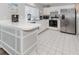 Well-lit kitchen featuring white countertops, modern appliances, and neutral cabinetry at 503 Clubside Cir # 47, Venice, FL 34293