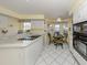 Bright kitchen featuring white cabinetry, an island with cooktop, and a cozy breakfast nook area at 503 Clubside Cir # 47, Venice, FL 34293