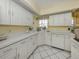 Kitchen area featuring white cabinetry and stainless-steel dishwasher, offering ample counter space at 503 Clubside Cir # 47, Venice, FL 34293