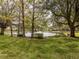 Scenic view of a community pond with mature trees and a fountain feature at 503 Clubside Cir # 47, Venice, FL 34293