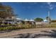 Picturesque view of the pond with a water fountain and community buildings with inviting poolside areas at 503 Clubside Cir # 47, Venice, FL 34293