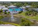 Gorgeous pool area with inviting blue umbrellas and comfortable seating for relaxation amidst lush landscaping at 503 Clubside Cir # 47, Venice, FL 34293