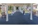 Covered walkway with a carpeted floor, white pillars and railings, plus comfortable seating at 503 Clubside Cir # 47, Venice, FL 34293