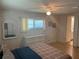 Bright bedroom features a window, ceiling fan, a mirror, and a dresser with wicker-style furniture at 508 Vasto Dr, Venice, FL 34285