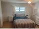 Cozy bedroom features a window, ceiling fan, two nightstands and a dresser with wicker-style furniture at 508 Vasto Dr, Venice, FL 34285
