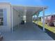 Attached carport providing covered parking and protection from the elements, next to a well maintained lawn at 508 Vasto Dr, Venice, FL 34285
