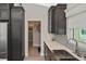 Modern kitchen with dark wood cabinetry, tiled backsplash, stainless steel sink, and doorway to a hallway at 509 Alhambra Rd, Venice, FL 34285