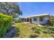 Spacious backyard featuring a well-manicured lawn, established landscaping, and a patio at 51 Oakwood N Dr # 51, Englewood, FL 34223