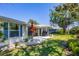 Well-maintained backyard with a patio, lush lawn, mature trees, and exterior access at 51 Oakwood N Dr # 51, Englewood, FL 34223