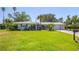 Charming single-story home with a well-manicured lawn and lush landscaping at 51 Oakwood N Dr # 51, Englewood, FL 34223