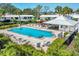 Community pool area with lounge chairs, a covered gazebo, and tropical landscaping at 51 Oakwood N Dr # 51, Englewood, FL 34223
