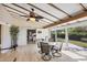 Bright sunroom with ceiling fan, outdoor access and tile floor adjacent to a bedroom space at 51 Oakwood N Dr # 51, Englewood, FL 34223