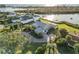 Panoramic aerial view highlighting a waterfront home with lush landscaping, and a private dock on the tranquil water at 524 Lyons Bay Rd, Nokomis, FL 34275