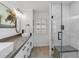This is a pristine bathroom with dual sinks, modern lighting, and a glass-enclosed shower with marble tiling at 524 Lyons Bay Rd, Nokomis, FL 34275
