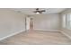A large bedroom with light wood floors, a ceiling fan and three plantation shutter windows at 524 Lyons Bay Rd, Nokomis, FL 34275