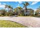 Beautiful home featuring a circular driveway, mature palm trees, and lush green landscaping at 524 Lyons Bay Rd, Nokomis, FL 34275