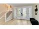 Bright foyer featuring wood floors, staircase with iron railings, and decorative glass double doors at 524 Lyons Bay Rd, Nokomis, FL 34275