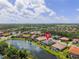 Aerial view of a neighborhood and the house location with a lake view and mature trees at 5550 Rock Dove Dr, Sarasota, FL 34241