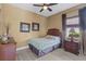 Cozy bedroom with a ceiling fan, light gray floors, and natural light at 5550 Rock Dove Dr, Sarasota, FL 34241