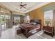 Comfortable main bedroom with tray ceiling, ceiling fan, ensuite bathroom and private lanai access at 5550 Rock Dove Dr, Sarasota, FL 34241