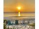 A calming beach view featuring chairs and a beautiful sunset on the horizon at 614 Pond Willow Ln, Venice, FL 34292