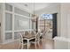 Dining area featuring a wood table, six chairs, decorative wall trim, and an arched window at 614 Pond Willow Ln, Venice, FL 34292