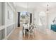 Bright dining room features a wood table, seating for six, neutral decor, and an arched window at 614 Pond Willow Ln, Venice, FL 34292