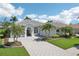 Beautiful single-story home featuring a paved driveway, arched windows, and meticulous landscaping at 614 Pond Willow Ln, Venice, FL 34292