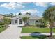 Beautiful single-story home with a gray tiled roof, arched windows, and a patterned paved driveway at 614 Pond Willow Ln, Venice, FL 34292