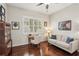 Cozy living room features hardwood floors, stylish sofa, and desk by the bright window at 614 Pond Willow Ln, Venice, FL 34292