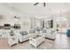 Open-concept living area featuring white sofas, tile floors, and views into the kitchen and dining space at 614 Pond Willow Ln, Venice, FL 34292