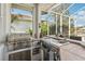 Outdoor kitchen featuring a stainless steel grill, countertop space, and views of the pool at 614 Pond Willow Ln, Venice, FL 34292