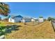 Backyard featuring grassy area, shed, and fence with palm trees nearby at 6392 Coliseum Blvd, Port Charlotte, FL 33981