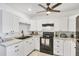 Stylish kitchen with white cabinets, modern black appliances, and a large sink with modern fixtures at 6392 Coliseum Blvd, Port Charlotte, FL 33981