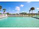 Community pool features a clear blue water and a view of the lake with palm trees at 6392 Coliseum Blvd, Port Charlotte, FL 33981