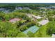 Aerial view of the tennis courts and lake on the property in a lovely green setting at 6639 Vista Ln, North Port, FL 34287