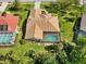 An aerial view of the backyard pool with screened-in enclosure and red clay tile roof at 7324 Links Ct, Sarasota, FL 34243