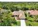 Beautiful home with a tile roof surrounded by mature trees and lush landscaping at 7324 Links Ct, Sarasota, FL 34243